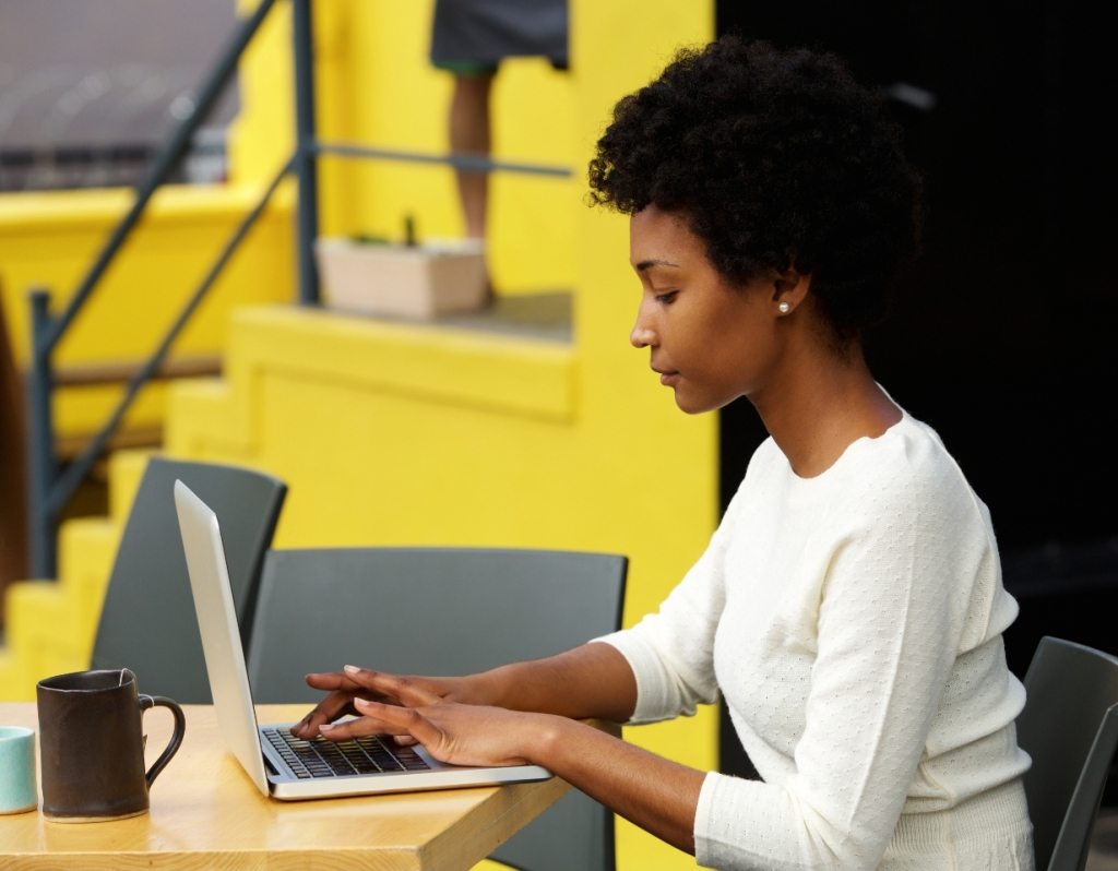 attractive-young-woman-using-laptop-outside-P9RLFGU